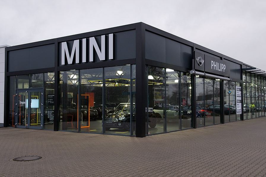 Außenansicht des MINI-Autohauses mit Glasfront und großem MINI-Logo.